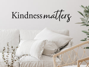 Living room wall decals that say ‘Kindness Matters’ in a script font on a living room wall. 