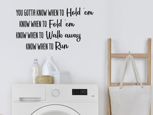 Laundry room wall decal that says ‘You Gotta Know When To Hold 'em Know When To Fold 'Em…’ on a laundry room wall