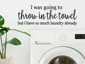 Decorative wall decal that says ‘I Was Going To Throw In The Towel But I Have So Much Laundry Already’ on a laundry room wall.