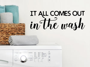 Laundry room wall decal that says ‘It All Comes Out In The Wash’ in a script font on a laundry room wall.