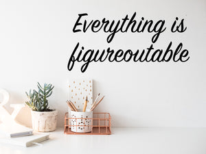 Wall decal for the office that says ‘Everything Is Figureoutable’ in a cursive font on an office wall.