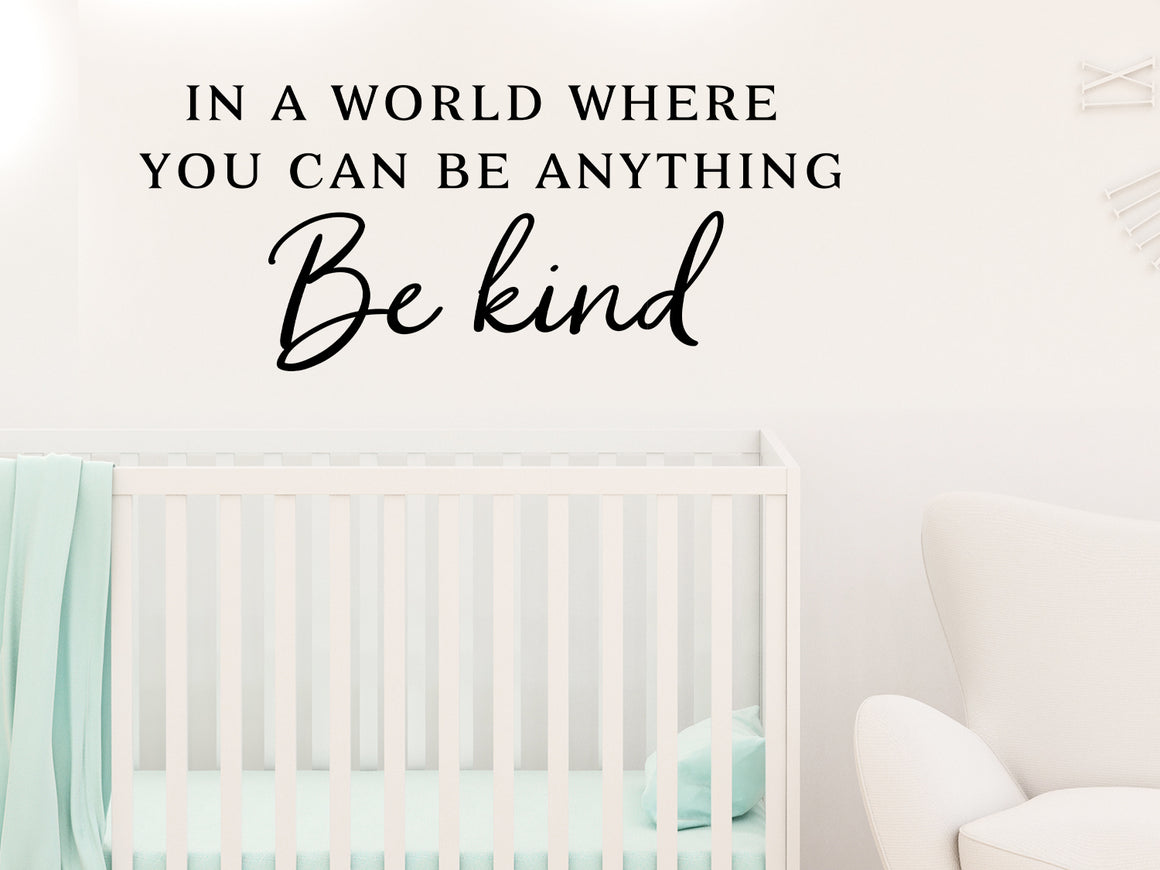 Wall decal for kids that says ‘In A World Where You Can Be Anything Be Kind’ in a script font on a kid’s room wall. 