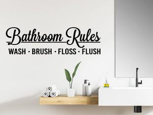 Wall decals for bathroom that say ‘Bathroom Rules Wash Brush Floss Flush’ in a cursive font on a bathroom wall.