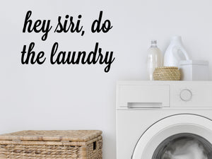 Laundry room wall decal that says ‘Hey Siri Do The Laundry’ in a cursive font on a laundry room wall