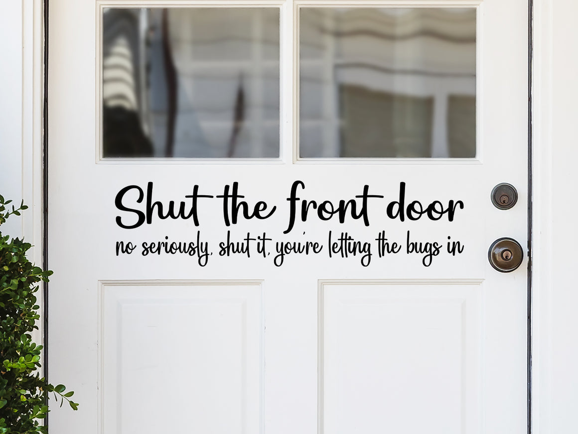 Front door decal that says, ‘shut the front door no seriously, shut it, you're letting the bugs in’ on a front porch door. 