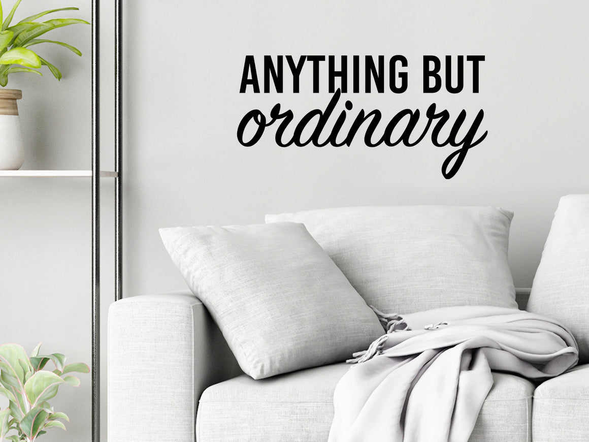 Living room wall decals that say ‘Anything But Ordinary’ in a script font on a living room wall. 