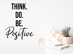 Wall decal for the office that says ‘Think Do Be Positive’ in a cursive font on an office wall.