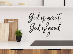 Wall decals for kitchen that say ‘God is Great, God Is Good’ in a cursive font on a kitchen wall.