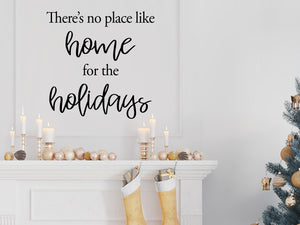 Living room wall decals that say ‘There Is No Place Like Home For The Holidays’ in a cursive font on a living room wall. 