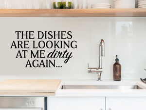 Wall decals for kitchen that say ‘The Dishes Are Looking At Me Dirty Again’ in a bold font on a kitchen wall.