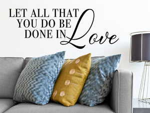 Living room wall decals that say ‘Let all that you do be done in love’ on a living room wall. 