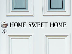 Front door decal that says, ‘Home sweet home’ on a front porch door. 