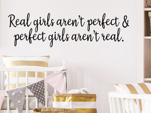 Wall decal for kids that says ‘Real girls aren't perfect & perfect girls aren't real.’ on a kid’s room wall. 