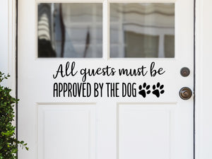 Front door decal that says, ‘All Guests Must Be Approved By The Dog’ on a front porch door.
