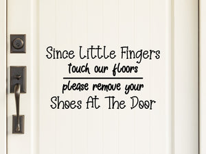 Wall decal for kids that says ‘Since little fingers touch our floors please remove your shoes at the door’ on a kid’s room wall. 