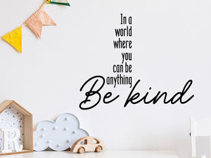 Wall decal for kids that says ‘In A World Where You Can Be Anything Be Kind’ in a bold font on a kid’s room wall.