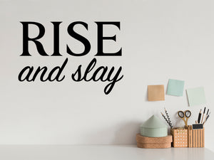 Wall decal for the office that says ‘Rise And Slay’ in a script font on an office wall.