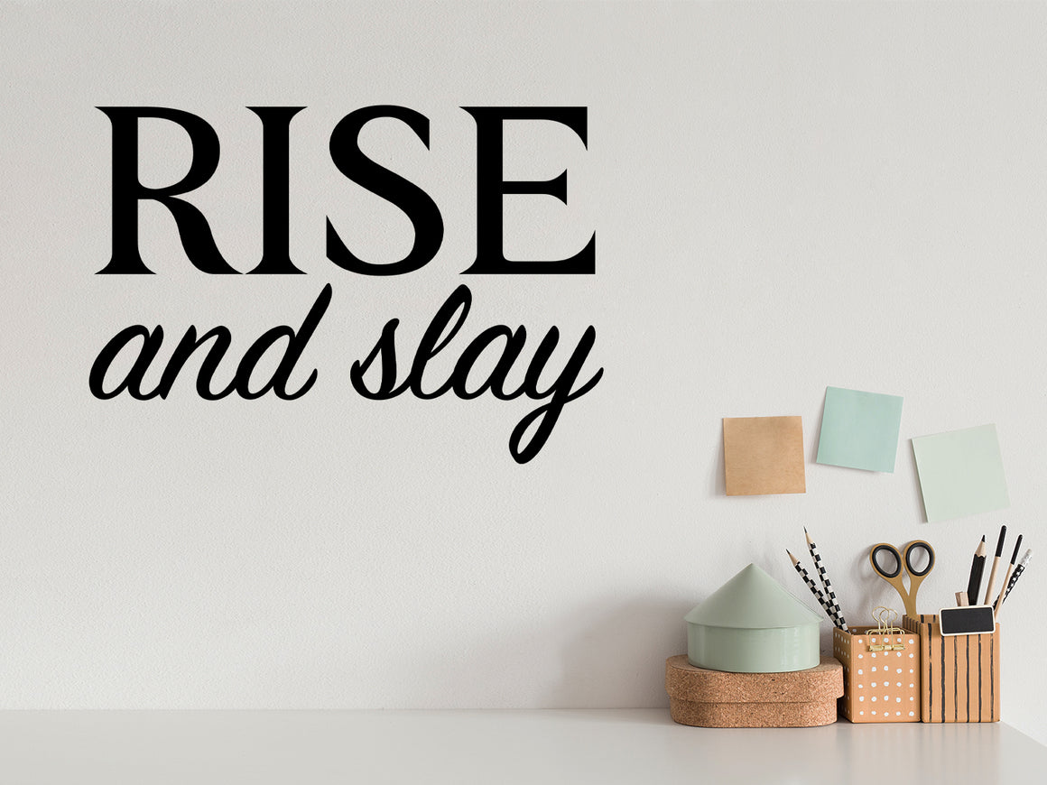 Wall decal for the office that says ‘Rise And Slay’ in a script font on an office wall.