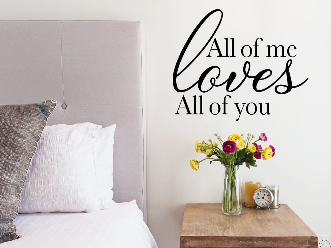 Wall decal for bedroom that says ‘All of me loves all of you’ on a bedroom wall.