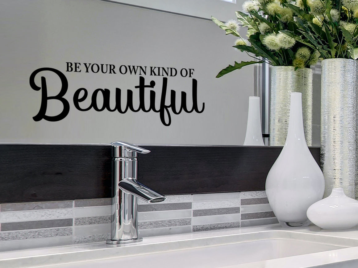 Wall decals for bathroom that say ‘Be Your Own Kind Of Beautiful’ in a script font on a bathroom wall.