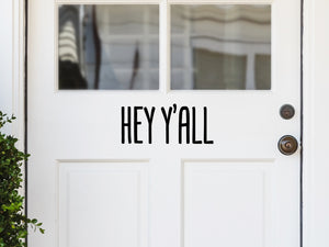 Front door decal that says, ‘Hey Ya’ll’ on a front porch door. 