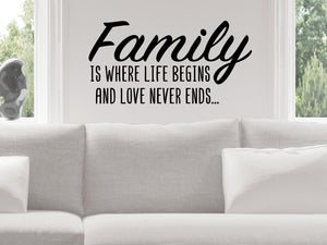Living room wall decals that say ‘Family Is Where Life Begins And Love Never Ends’ in a bold font on a living room wall. 