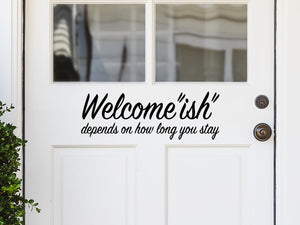 Front door decal that says, ‘Welcomeish Depends On How Long You Stay’ on a front porch door. 