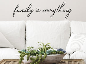 Living room wall decals that say ‘Family Is Everything’ in a cursive font on a living room wall. 