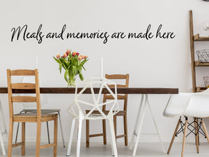 Wall decals for kitchen that say ‘Meals And Memories Are Made Here’ in a cursive font on a kitchen wall.