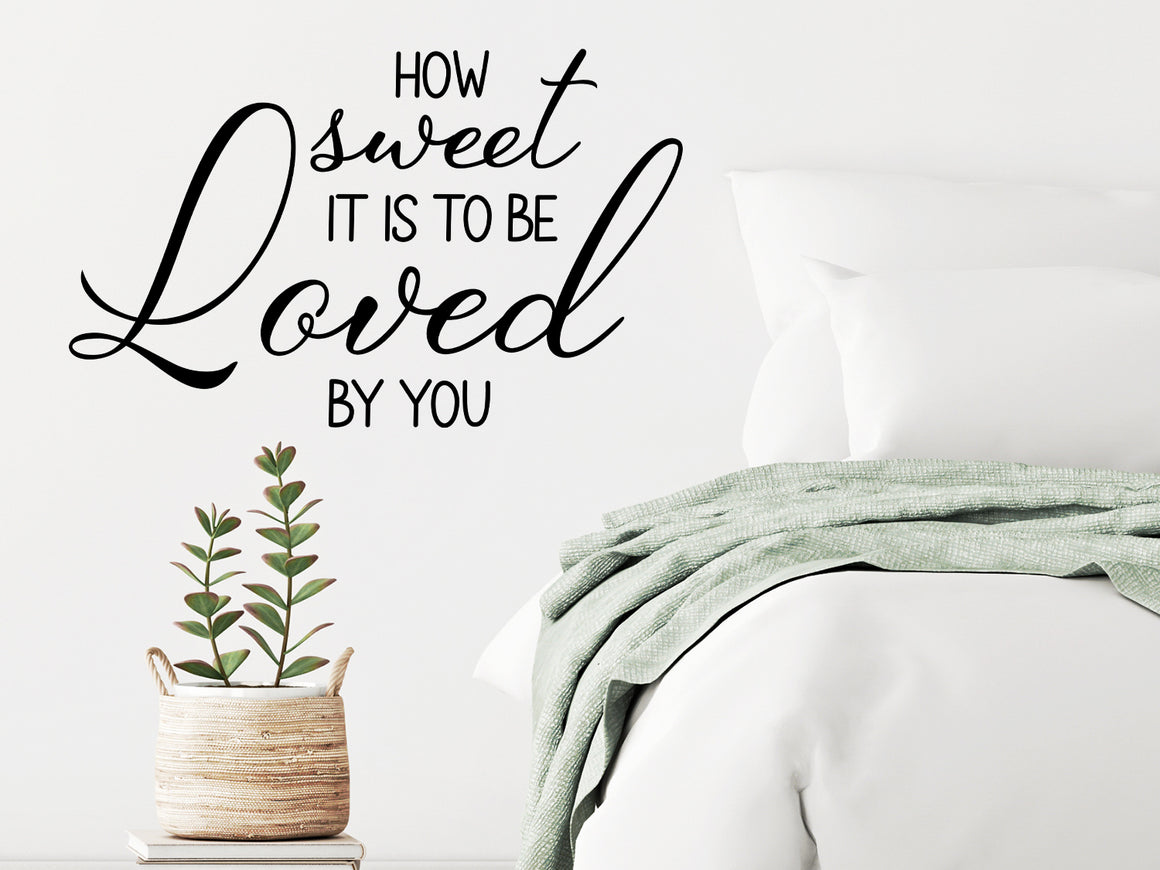 Wall decal for bedroom that says ‘how sweet it is to be loved by you’ on a bedroom wall.