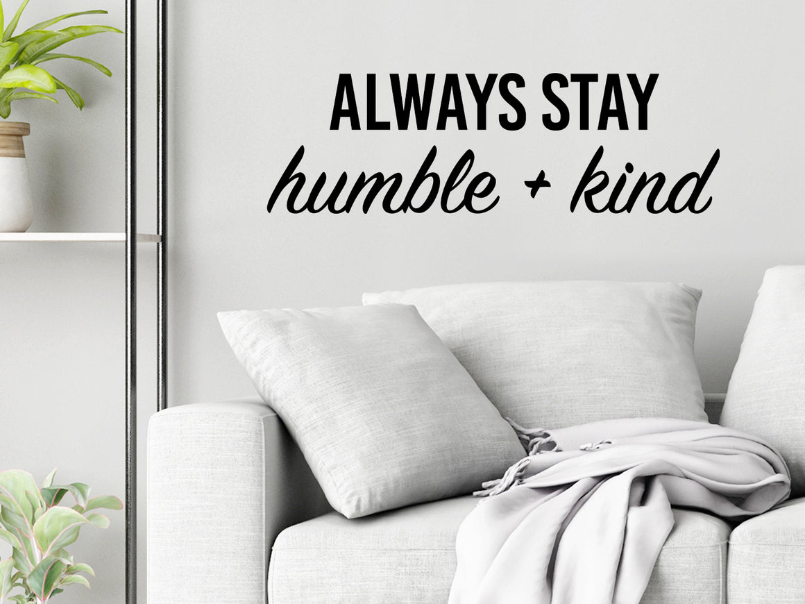 Living room wall decals that say ‘Always Stay Humble And Kind’ in a bold font on a living room wall. 