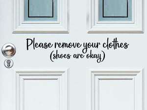 Front door decal that says, ‘Please remove your clothes, shoes are okay’ in a script font on a front porch door. 