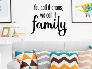 Living room wall decals that say ‘you call it chaos, we call it family’ on a living room wall. 