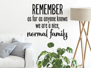 Living room wall decals that say 'remember as far as anyone know we are a nice, normal family’ in print on a living room wall. 