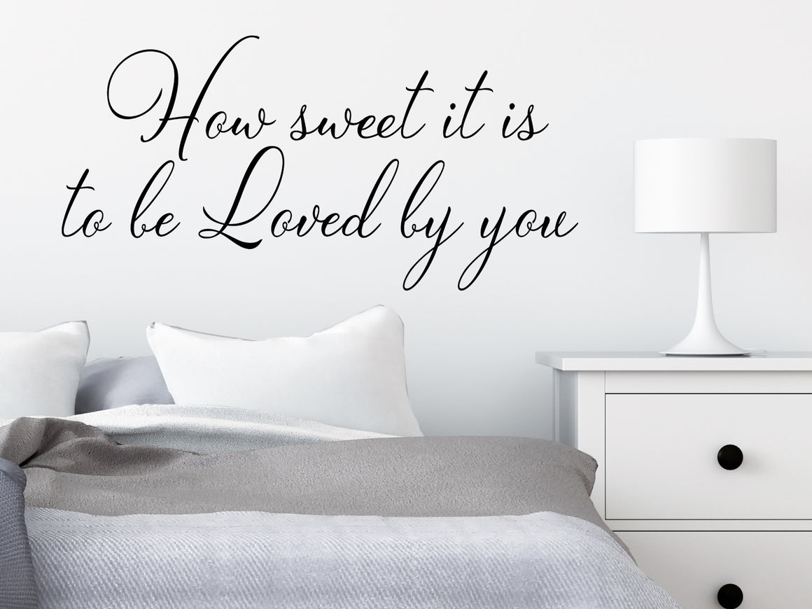 Wall decal for bedroom that says ‘how sweet it is to be loved by you’ on a bedroom wall.