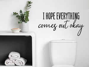 Wall decals for bathroom that say ‘I Hope Everything Comes Out Okay’ in a cursive font on a bathroom wall.