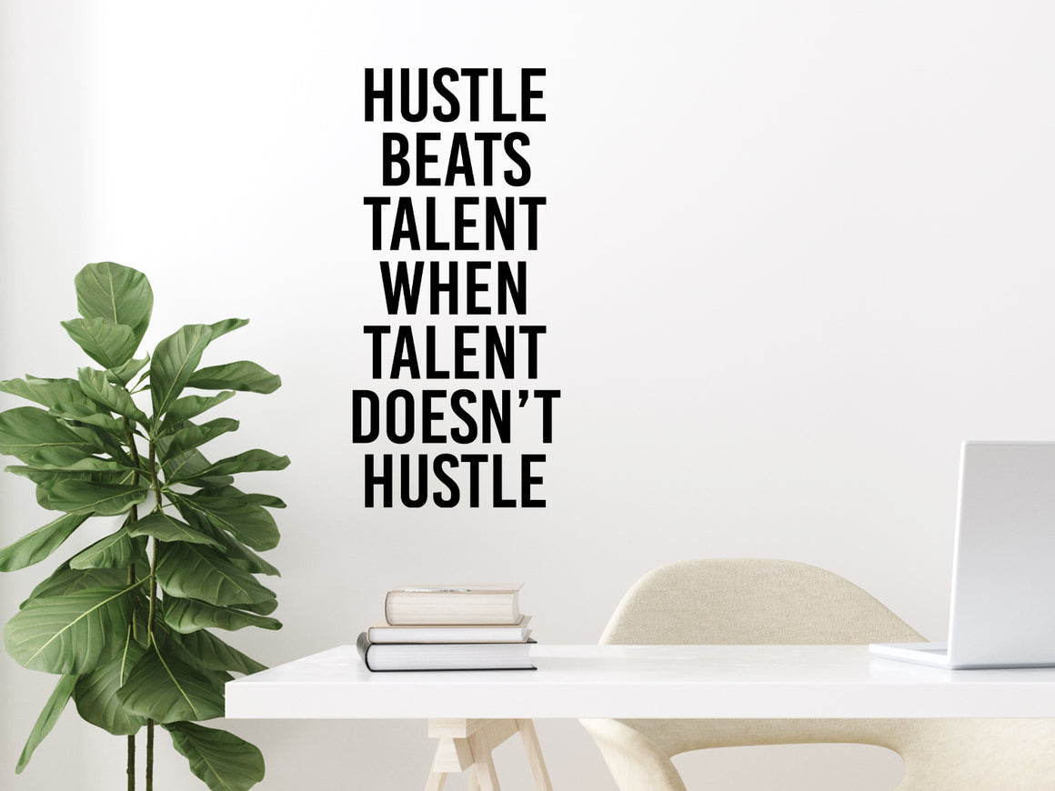 Wall decal for the office that says ‘Hustle Beats Talent When Talent Doesn’t Hustle’ in a bold font on an office wall.