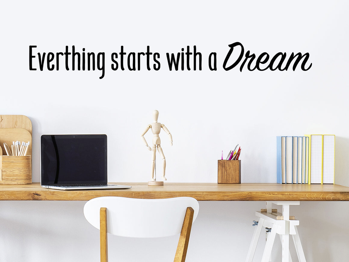 Wall decal for the office that says ‘Everything Starts With A Dream’ in a bold font on an office wall.