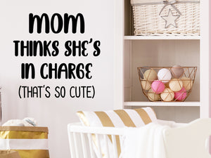 Wall decal for kids that says ‘Mom thinks she's in charge that's so cute’ on a kid’s room wall. 