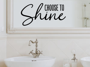 Wall decals for bathroom that say ‘Choose To Shine’ in a cursive font on a bathroom wall.