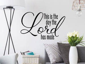 Living room wall decals that say ‘this is the day the Lord has made’ on a living room wall. 