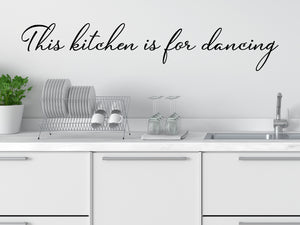 Wall decals for kitchen that say ‘This Kitchen Is For Dancing’ in a cursive font on a kitchen wall.