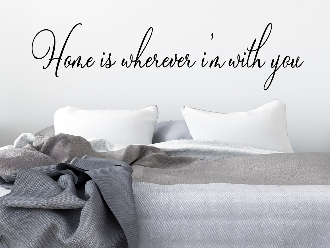 Wall decal for bedroom that says ‘home is wherever i'm with you’ on a bedroom wall.