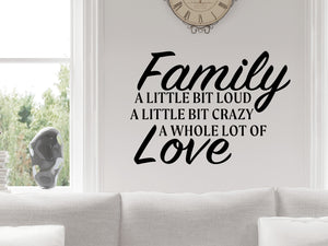 Living room wall decals that say ‘Family A Little Bit Loud A Little Bit Crazy & A Whole Lot Of Love’ in a bold font on a living room wall. 
