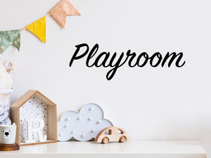 Wall decal for kids that says ‘Playroom’ in a cursive font on a kid’s room wall. 