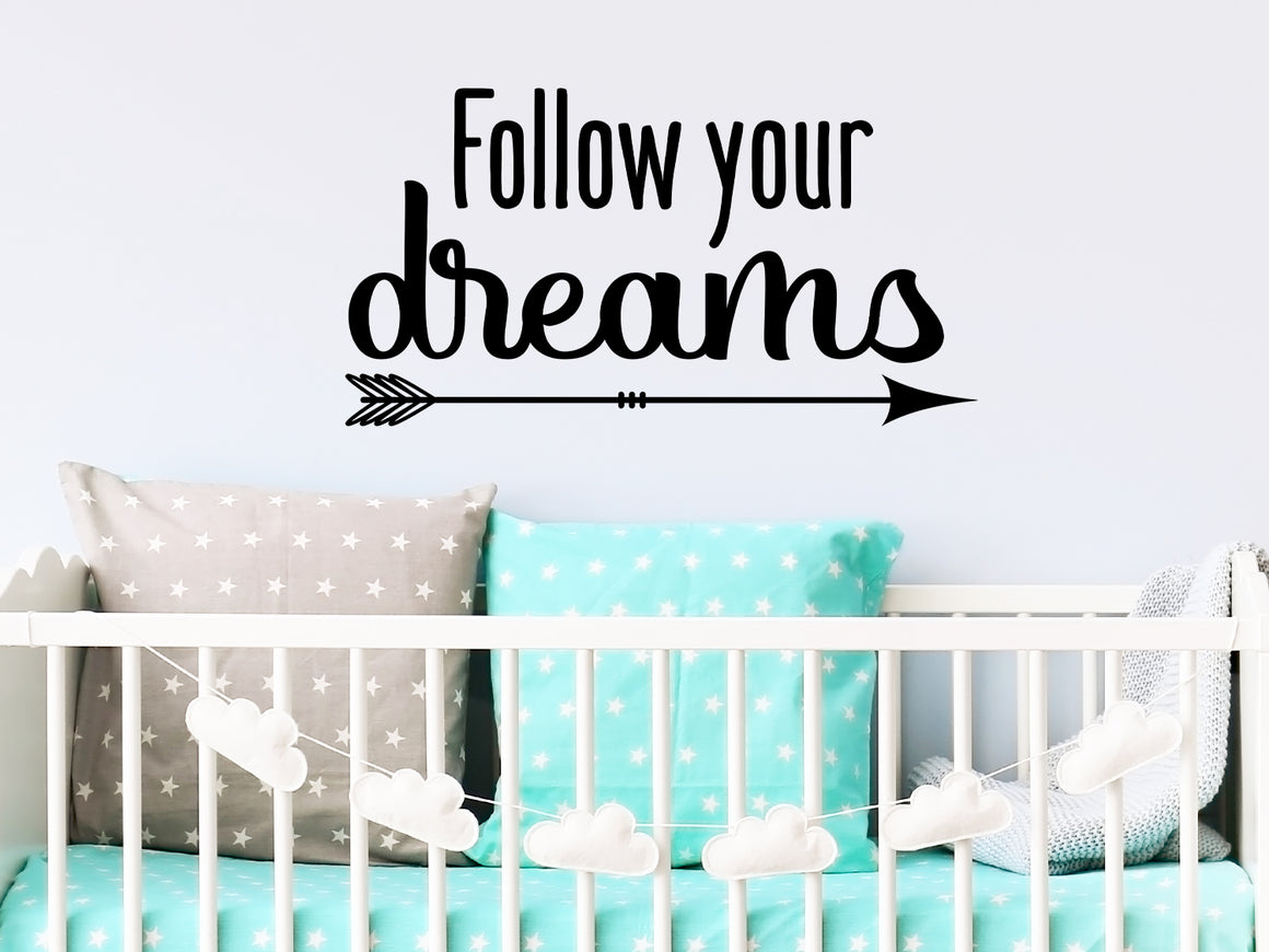 Wall decal for kids that says ‘Follow Your Dreams’ in a script font on a kid’s room wall. 