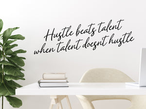 Wall decal for the office that says ‘Hustle Beats Talent When Talent Doesn’t Hustle’ in a cursive font on an office wall.