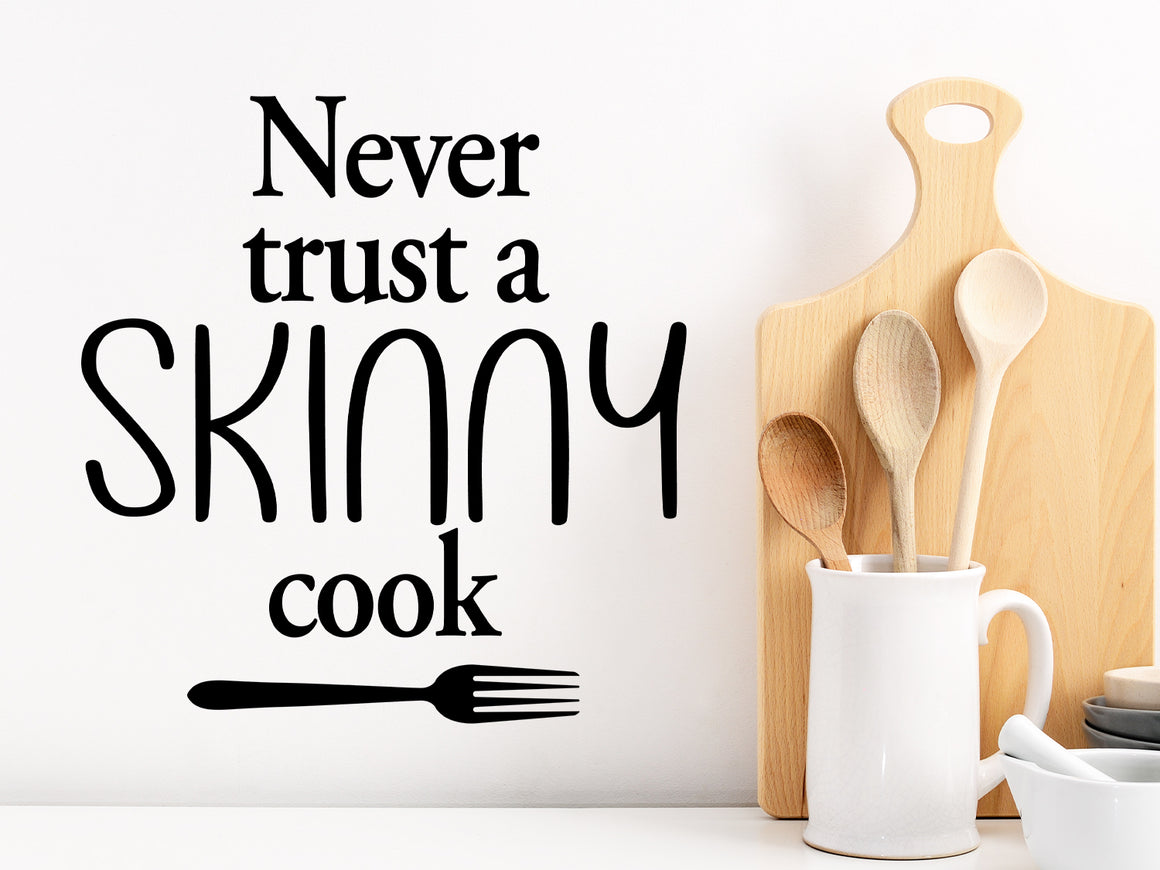 Decorative wall decal that says ‘Never Trust A Skinny Cook’ on a kitchen wall.
