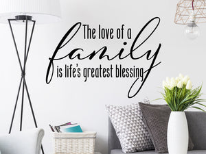 Living room wall decals that say ‘The love of a family is life's greatest blessing’ on a living room wall. 