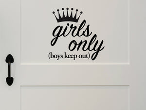 Wall decal for kids that says ‘Boys Keep Out Girls Only’ with a crown design on a kid’s room wall. 
